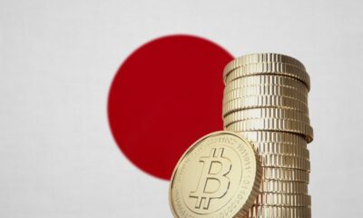 A stack of Bitcoin coins with the Japanese flag in the background.