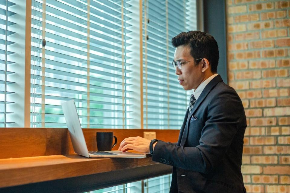 Person sitting in front of a laptop in a cafe.