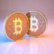 Bitcoin digital currency sitting on metallic blue and pink background